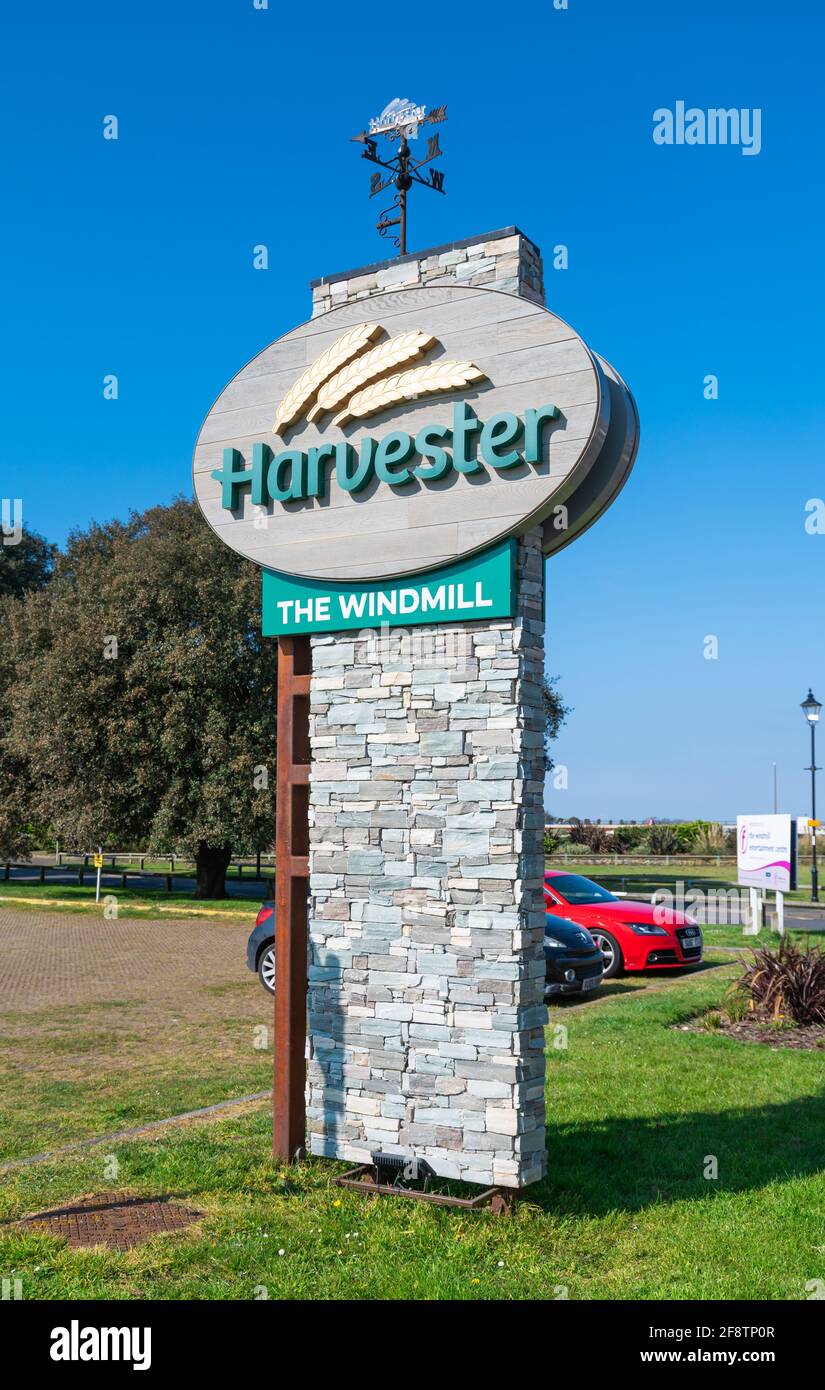 Sign at the entrance to The Harvester restaurant at The Windmill in Littlehampton, West Sussex, England, UK. Part of the Harvester restaurant chain. Stock Photo