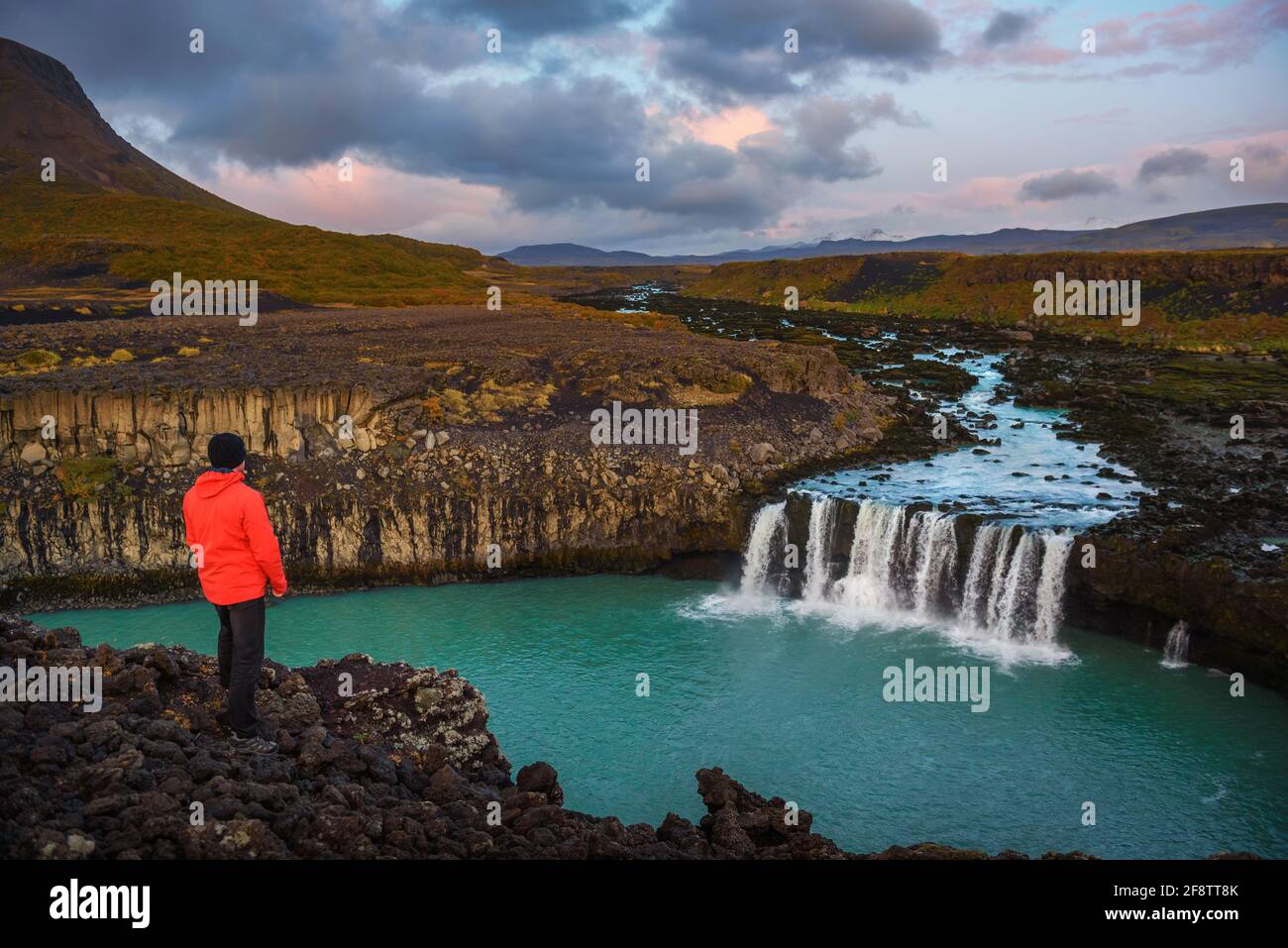 Hiker standing at the edge of the Thjofafoss waterfall in Iceland Stock Photo