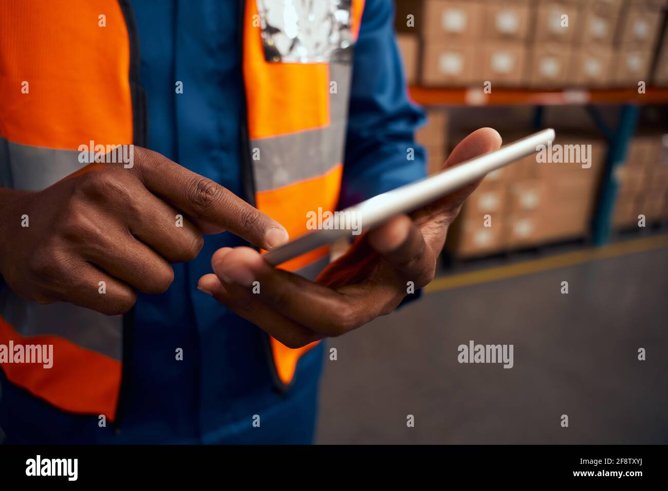 Midsection of a male worker pointing at digital tablet in factory Stock Photo
