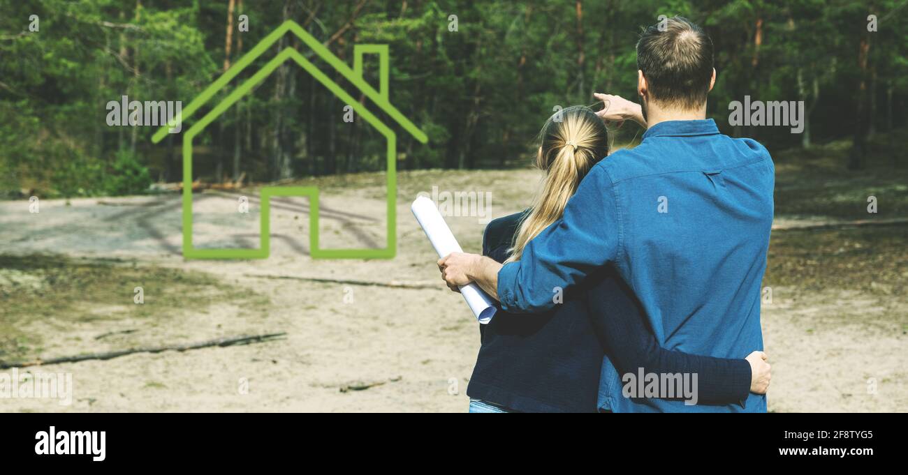 young couple looking for plot of land and dreaming about small forest lodge Stock Photo