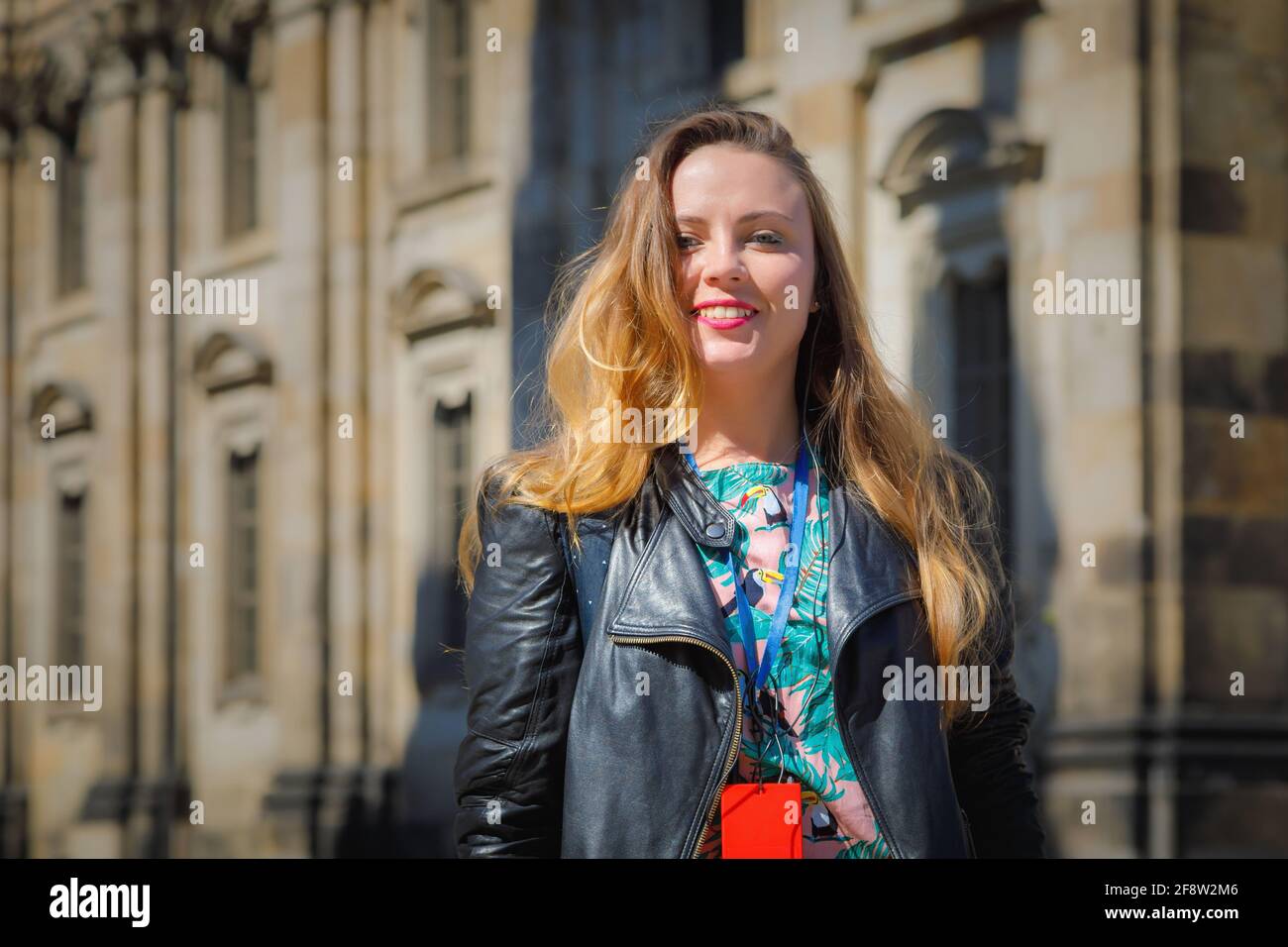 A young beautiful girl walks around the city on excursions. Cheerful, happy laugh. Stock Photo