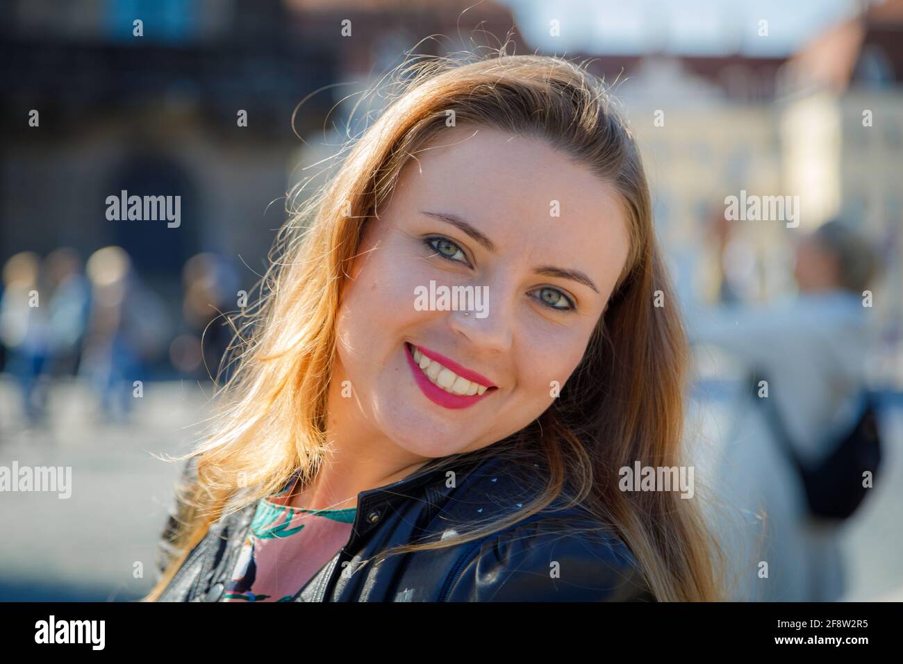 A young beautiful girl walks around the city on excursions. Cheerful, happy laugh. Stock Photo