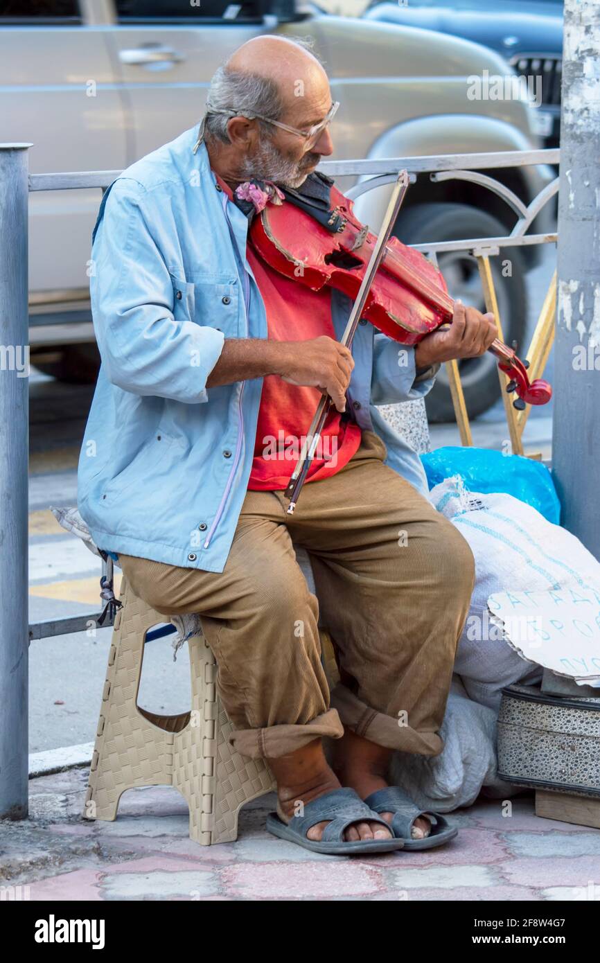 Old Jew plays violin in street. Sunny summer day. Front view. Crimea, Sudak - 10 October 2020. Stock Photo