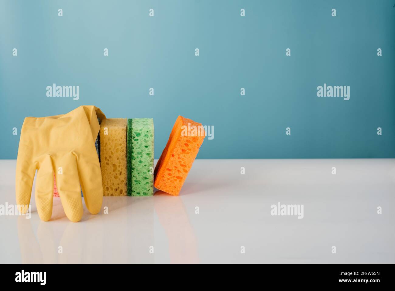 Spring Sponge Clean Up Colorful cleaning sponges with soap bubbles on blue background ...