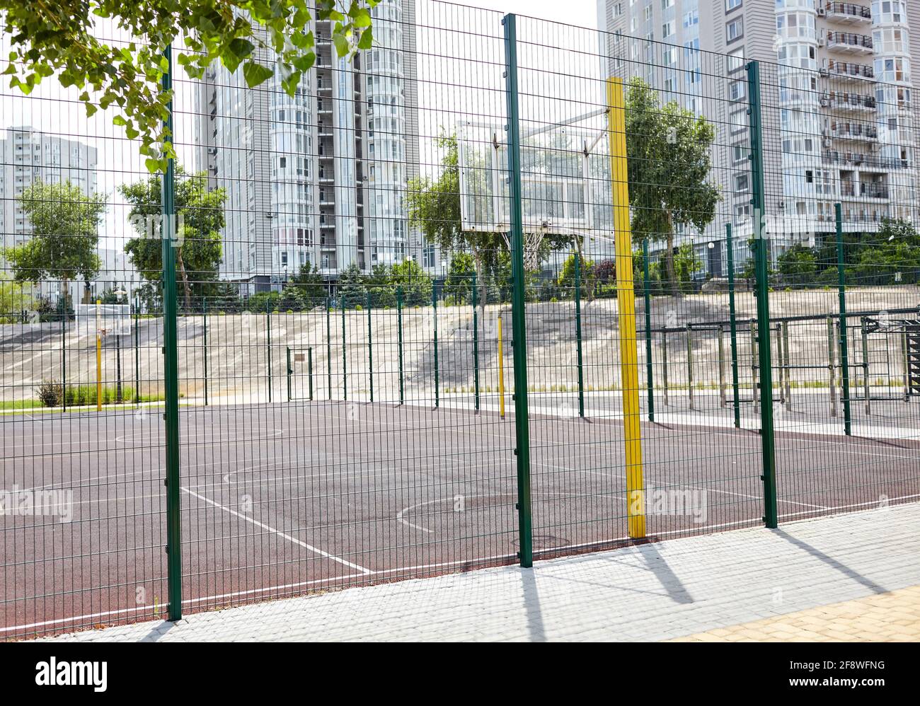 Basketball court from behind fence. Basketball hoop in the city park