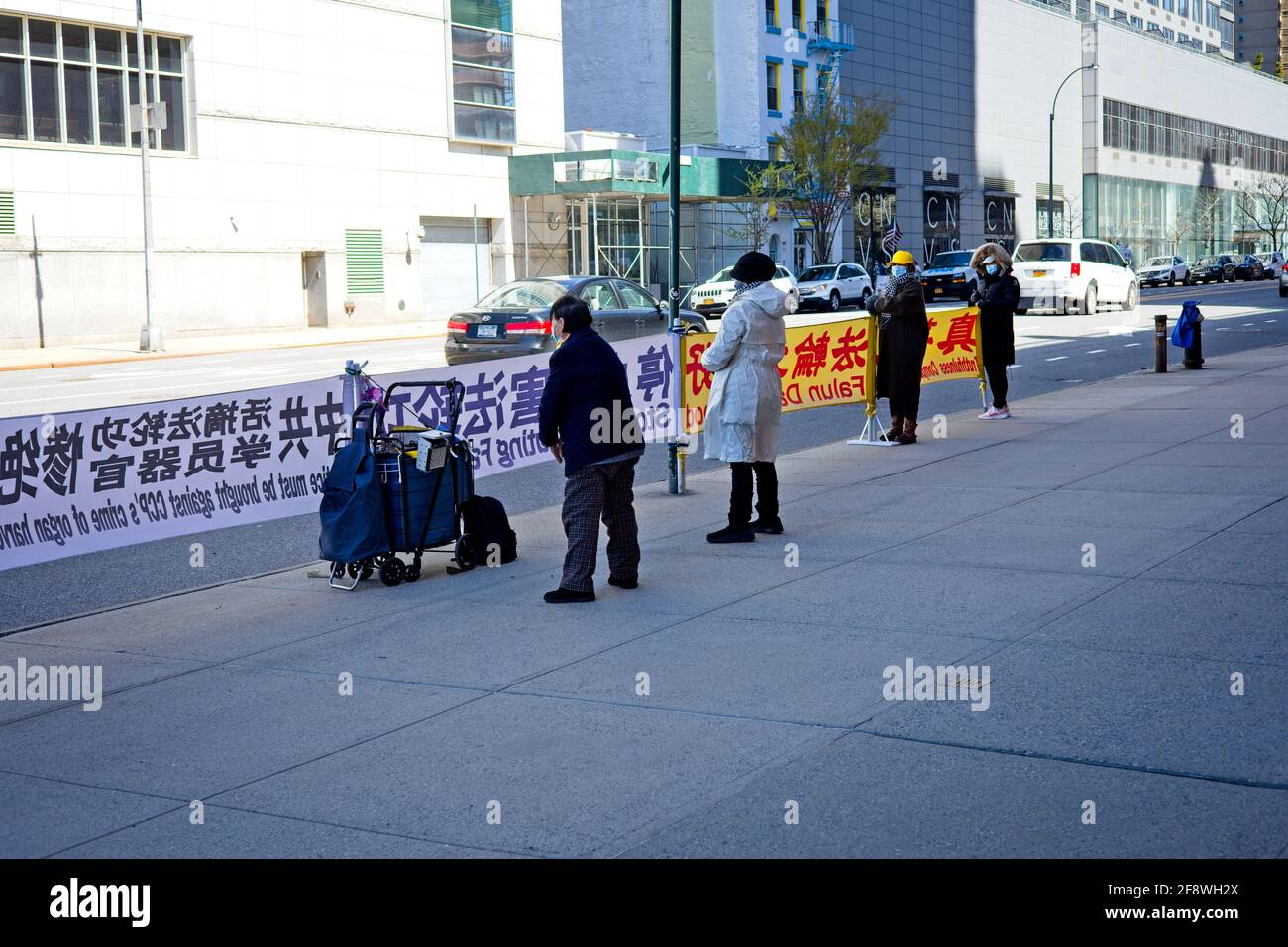 New York, NY, USA - April 14, 2021: Falun Gong Chinese spiritual movement with signs facing W 42nd Street in Manhattan Stock Photo