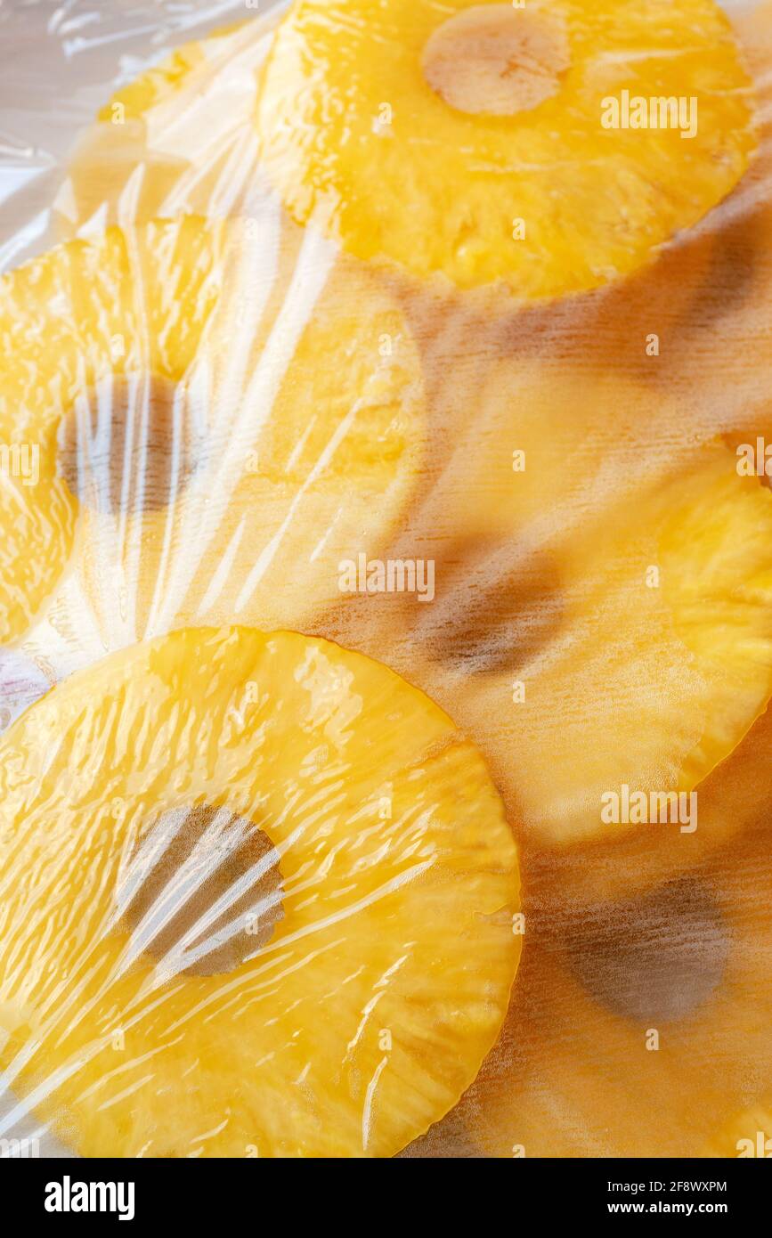 Slices of Fresh Pineapple Ananas Covered With Plastic Wrap Stock Photo