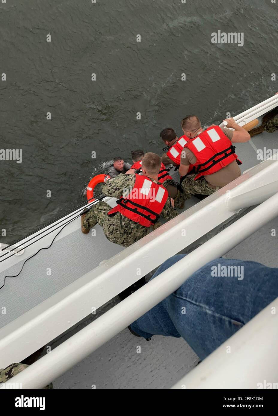 Crew of the U.S. Coast Guard Cutter Glenn Harris, pulls a person from the water after the Seacor Power, 175-foot commercial lift boat capsized in stormy seas in the Gulf of Mexico April 13, 2021, 8 miles south of Grand Isle, Louisiana. The Coast Guard rescued six people from the oil service ship and 12 are still missing. Credit: Planetpix/Alamy Live News Stock Photo