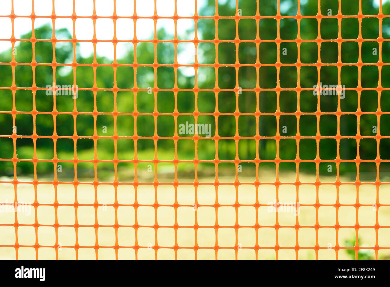 Plastic safety net for construction site. Construction mesh on winter snow background. Stock Photo