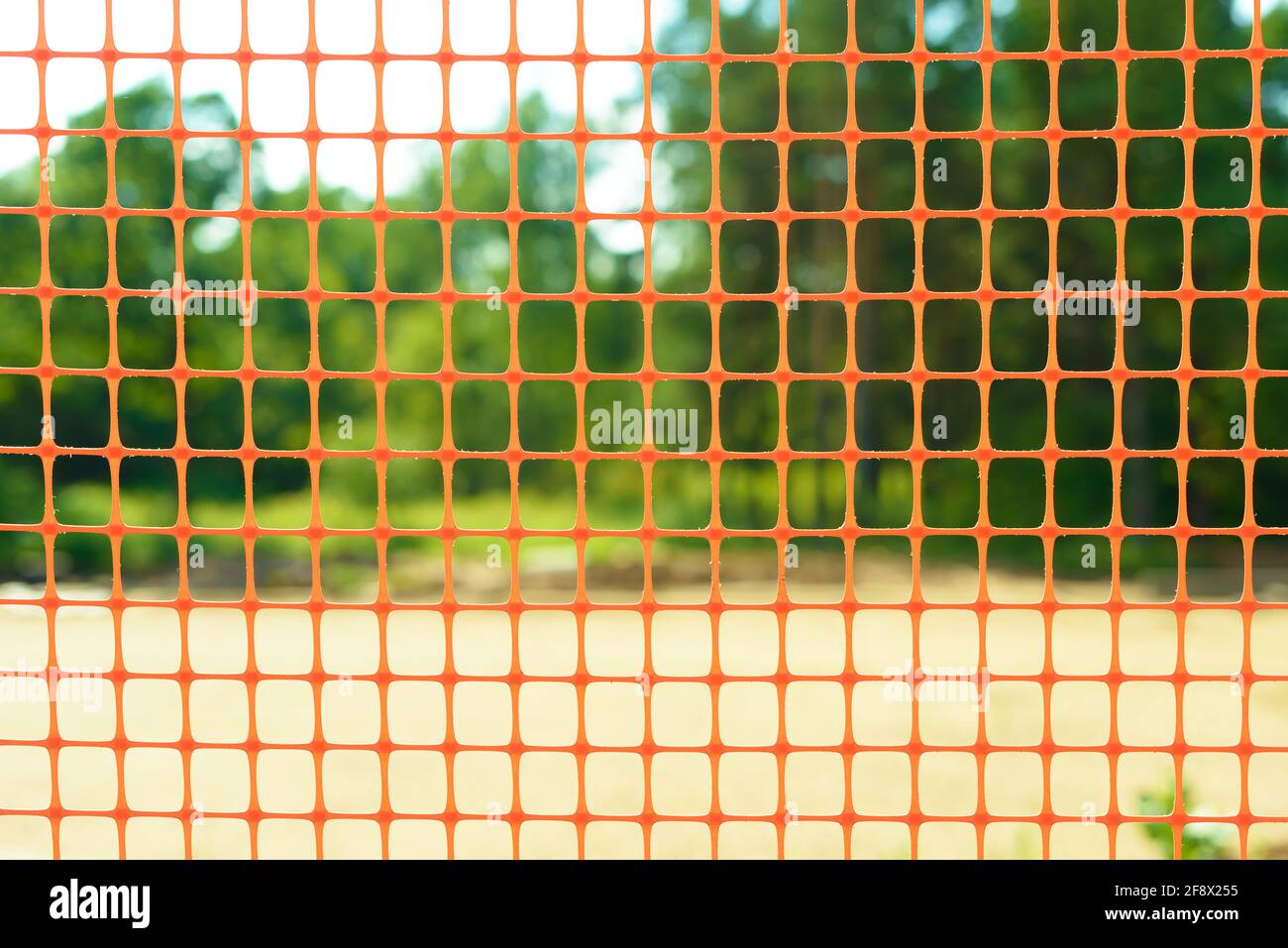 Plastic safety net for construction site. Construction mesh on winter snow background. Stock Photo