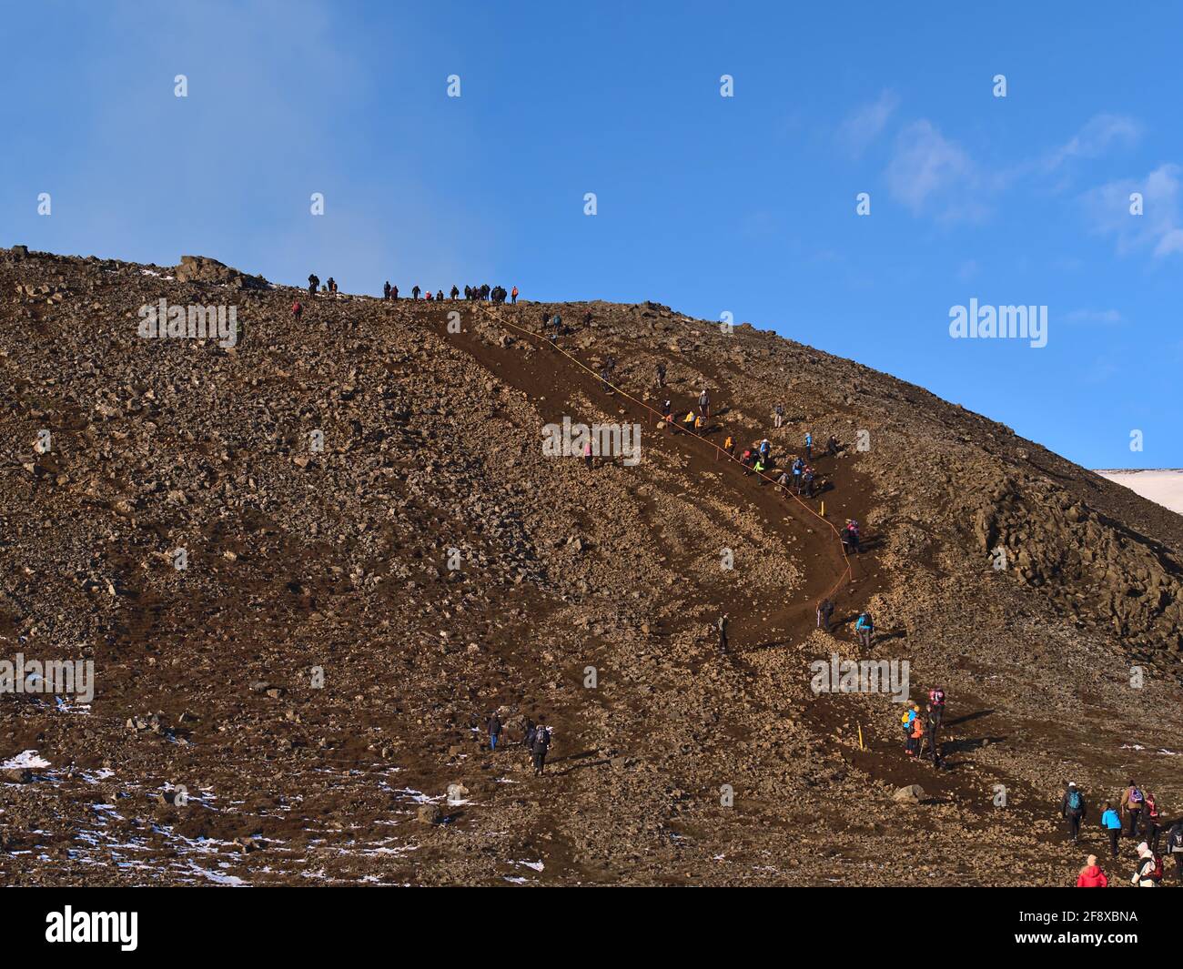 People climbing up a slope on the hiking path to recently started volcanic eruption at Fagradalsfjall mountain in the Geldingadalir valleys, Iceland. Stock Photo