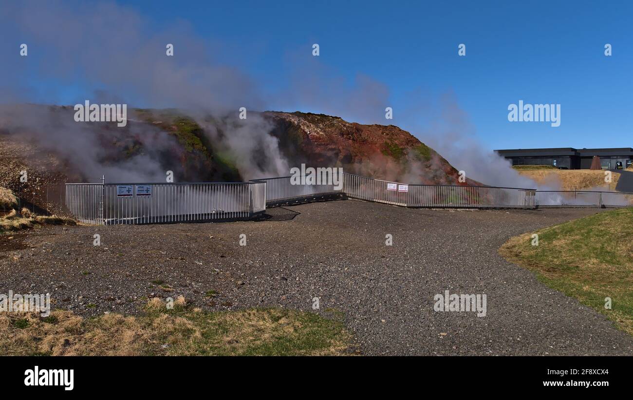 Deildartunguhver hot springs in Reykholt in Borgarbyggð community in west Iceland with the steam of hot water behind a metal railing. Stock Photo