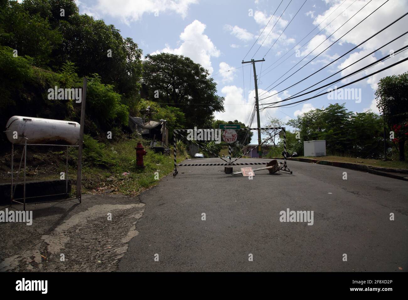Happy Hill Grenada Police barrier Road Block with Water Tank on roadside Stock Photo