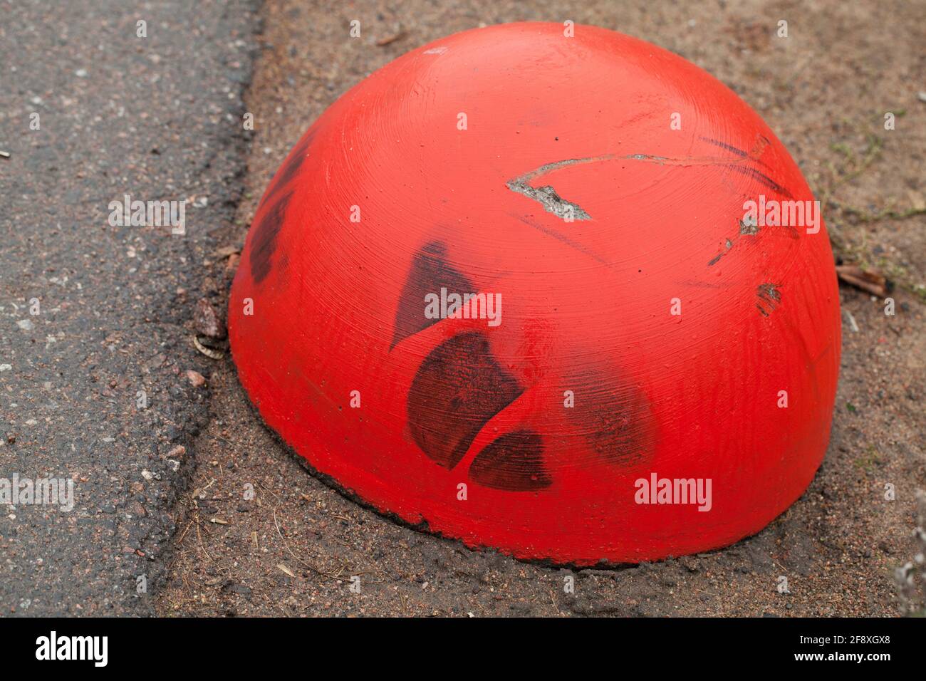 Red concrete anti-parking hemisphere-shaped bollard, close up photo Stock Photo