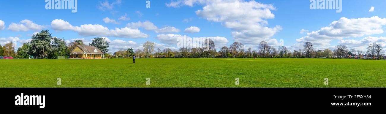 A panoramic view of Sol Joel Park, in Earley, Reading, UK. An open green, public space on a day with. blue sky and clouds. Stock Photo