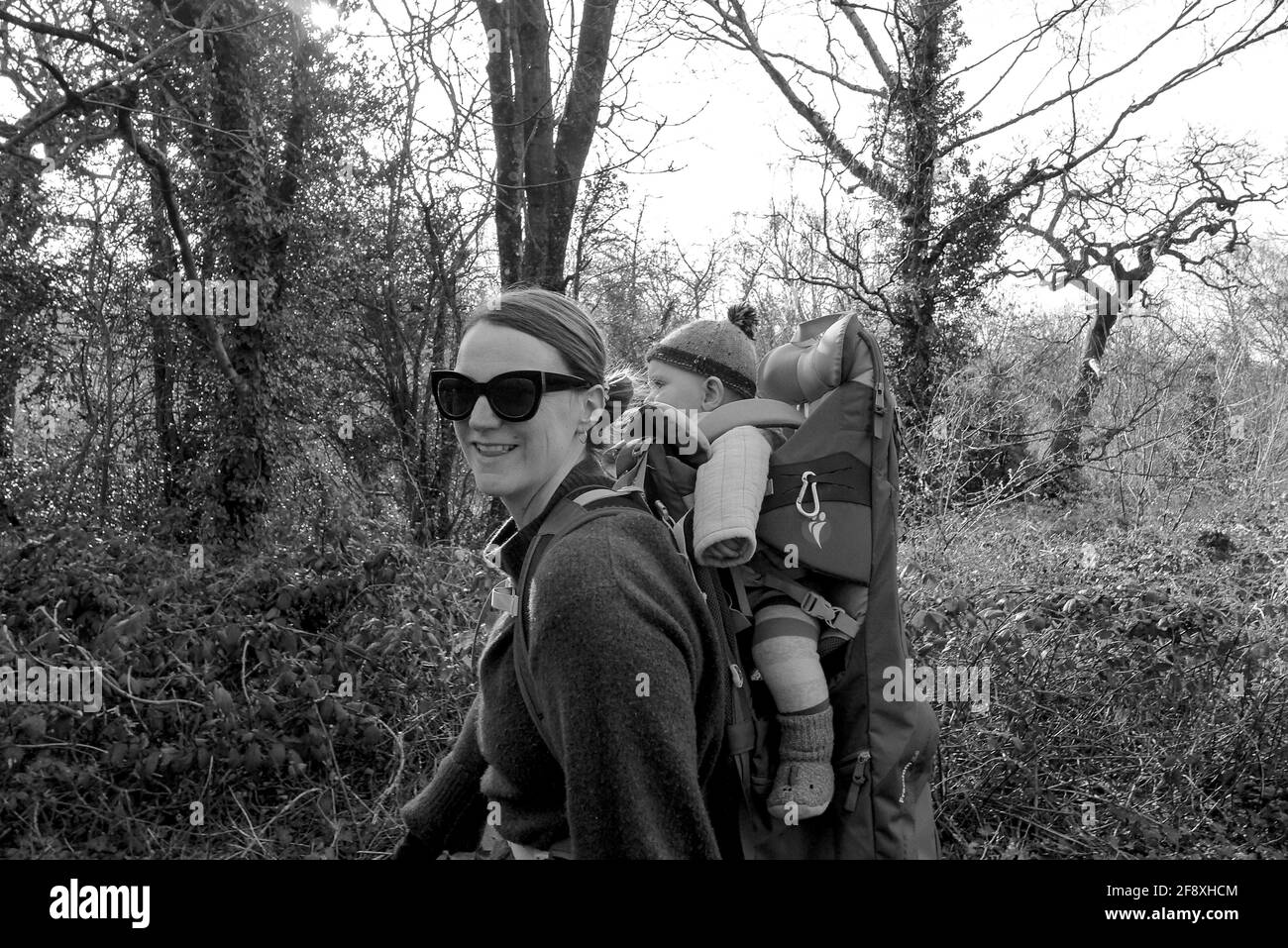 Mother and son on the carrier walking in the woodland. Black and white Stock Photo