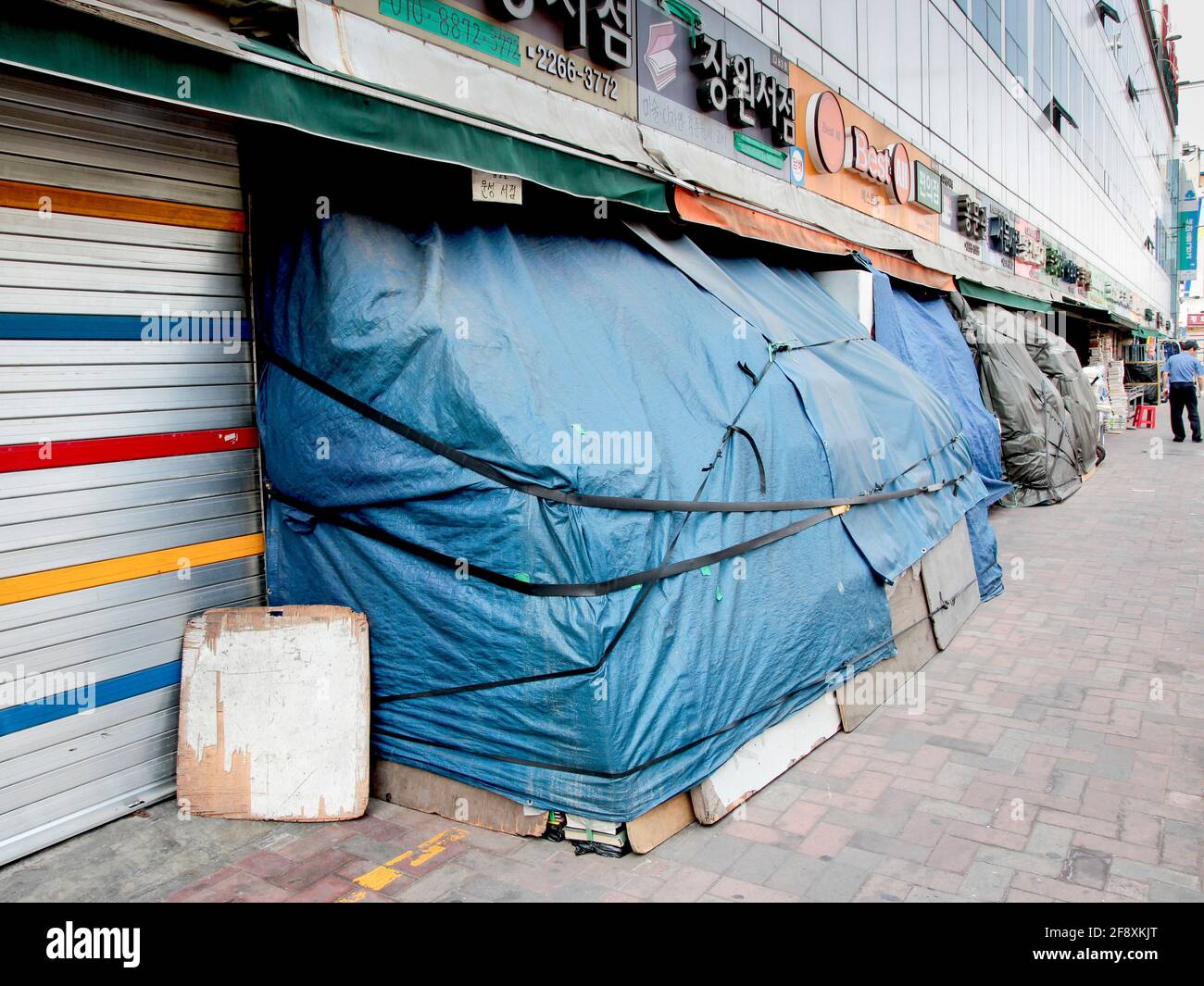 Businesses with tarps covering them while they are closed. In Seoul, South Korea. Stock Photo