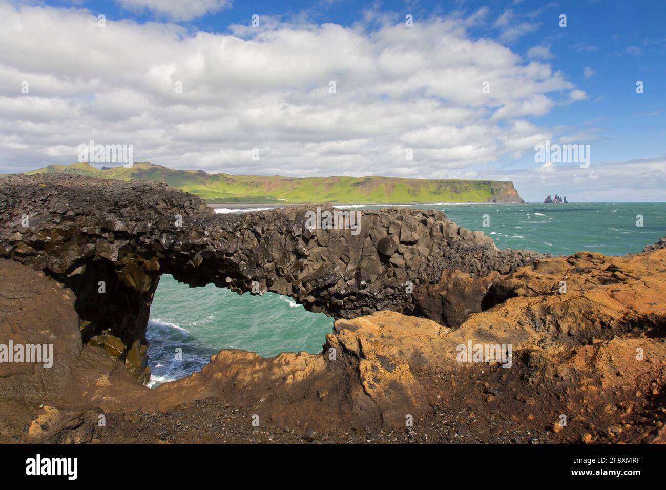 Natural arch, eroded black basalt rock formation at Cape Dyrhólaey / Cape Portland near Vík í Mýrdal, Iceland Stock Photo