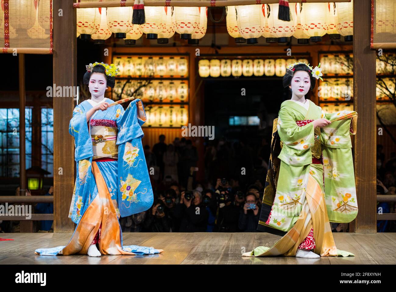 Geisha wearing kimono dancing and performing on stage in front of audience. Beautiful and elegant maiko. Yasaka Shrine, Kyoto, Japan. Stock Photo