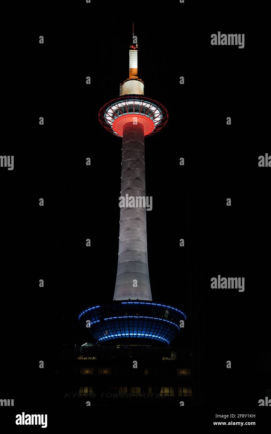 The Kyoto Tower is brightly illuminated with neon lights at night
