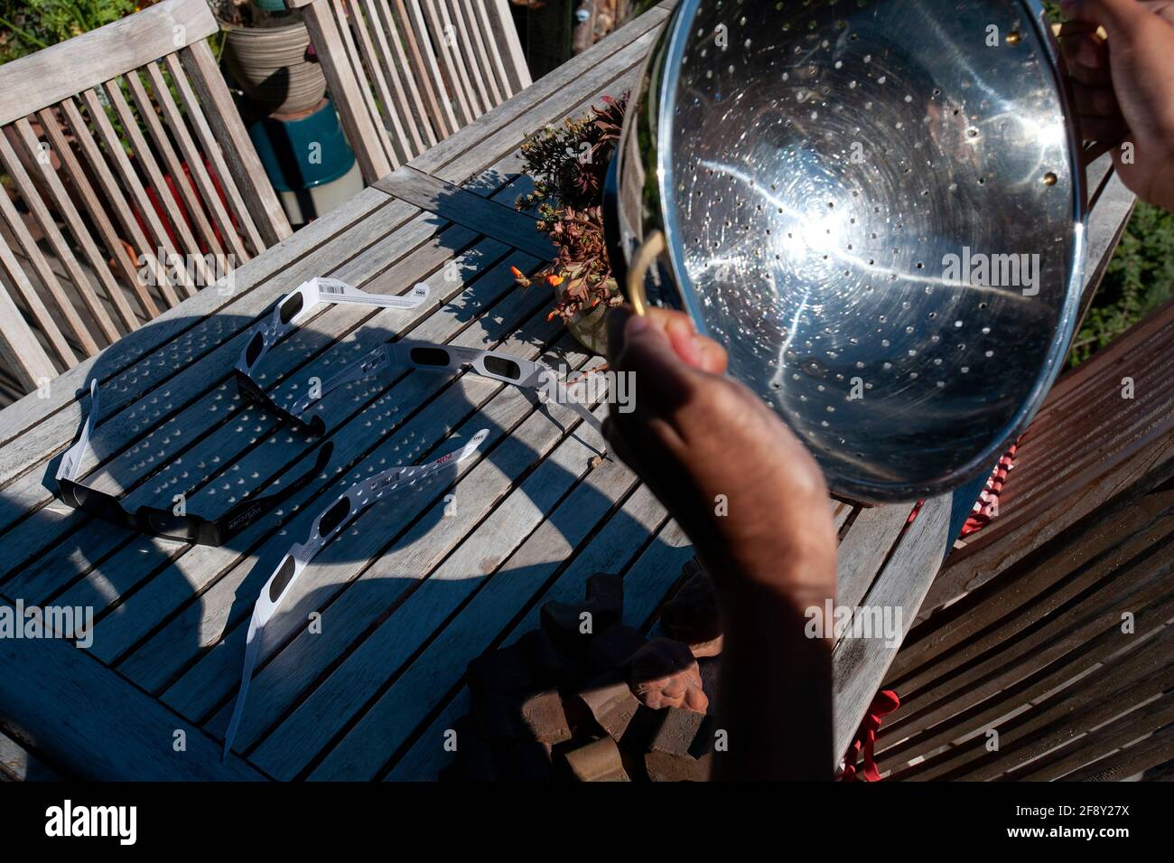 Person holding strainer to view Solar Eclipse of 2017. Stock Photo