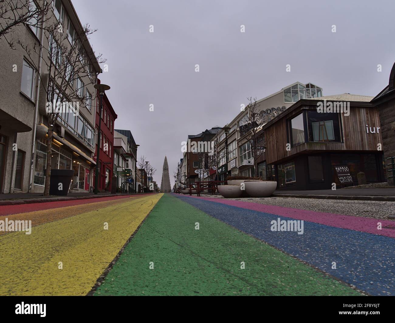 View of empty rainbow road in Reykjavik downtown, dedicated to the Reykjavik Pride Gay Festival, with famous Hallgrímskirkja church in winter. Stock Photo