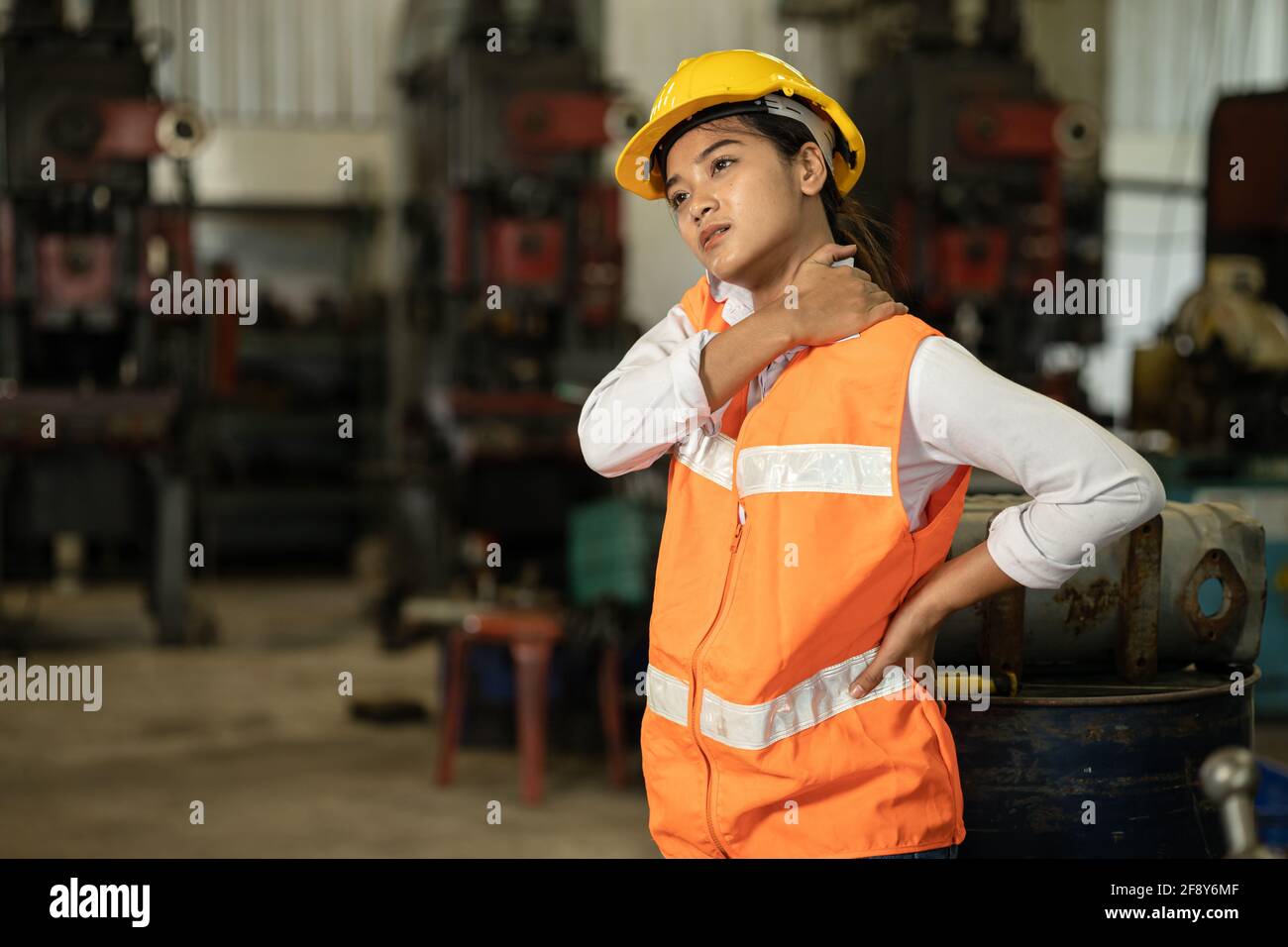 Tired stress women worker neck pain working in heavy industry factory, health problem asian labor concept. Stock Photo