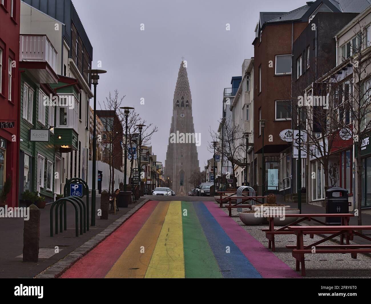 View of empty rainbow street in Reykjavik city center, dedicated to the annual Reykjavik Pride Gay Festival, with Hallgrímskirkja church on cloudy day. Stock Photo