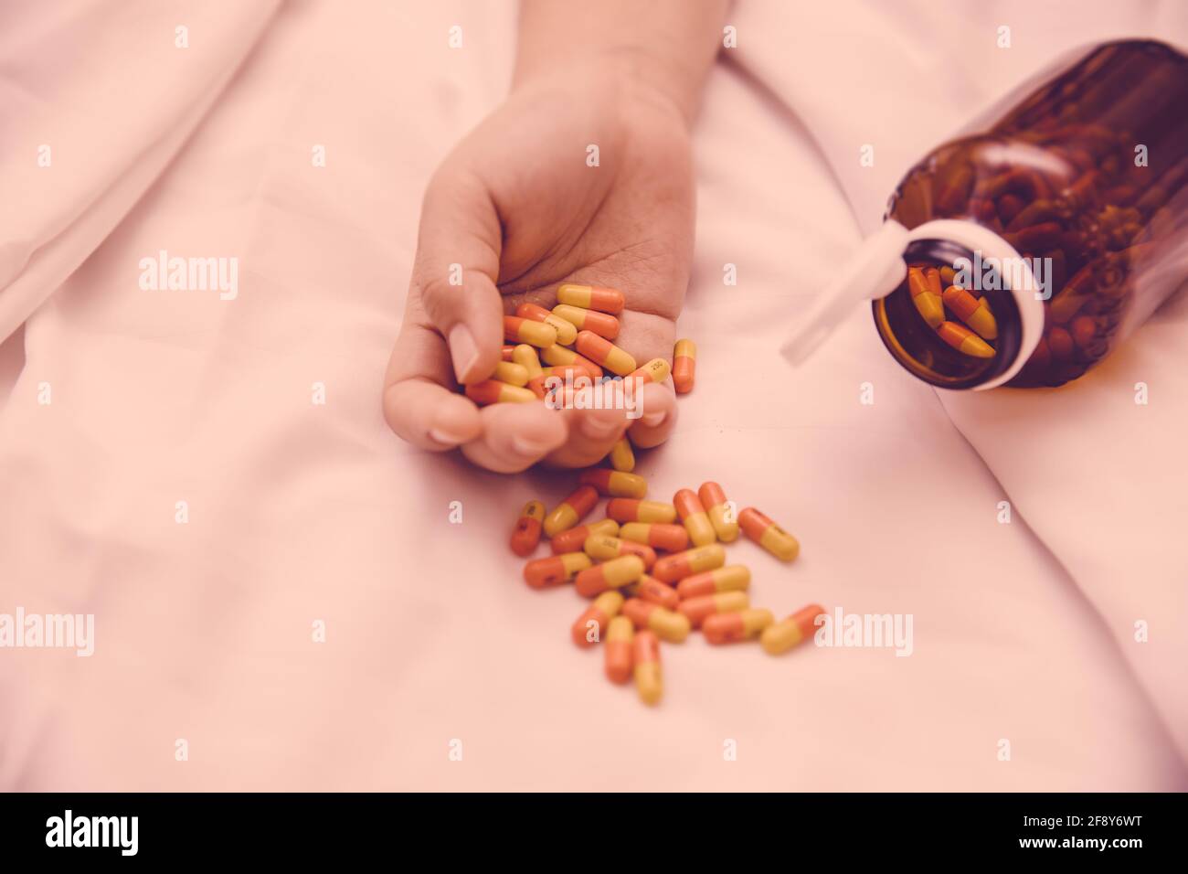 Suicide attempts by drug overdose concept, Many Capsule pills are on women hand who die from drugs. Stock Photo