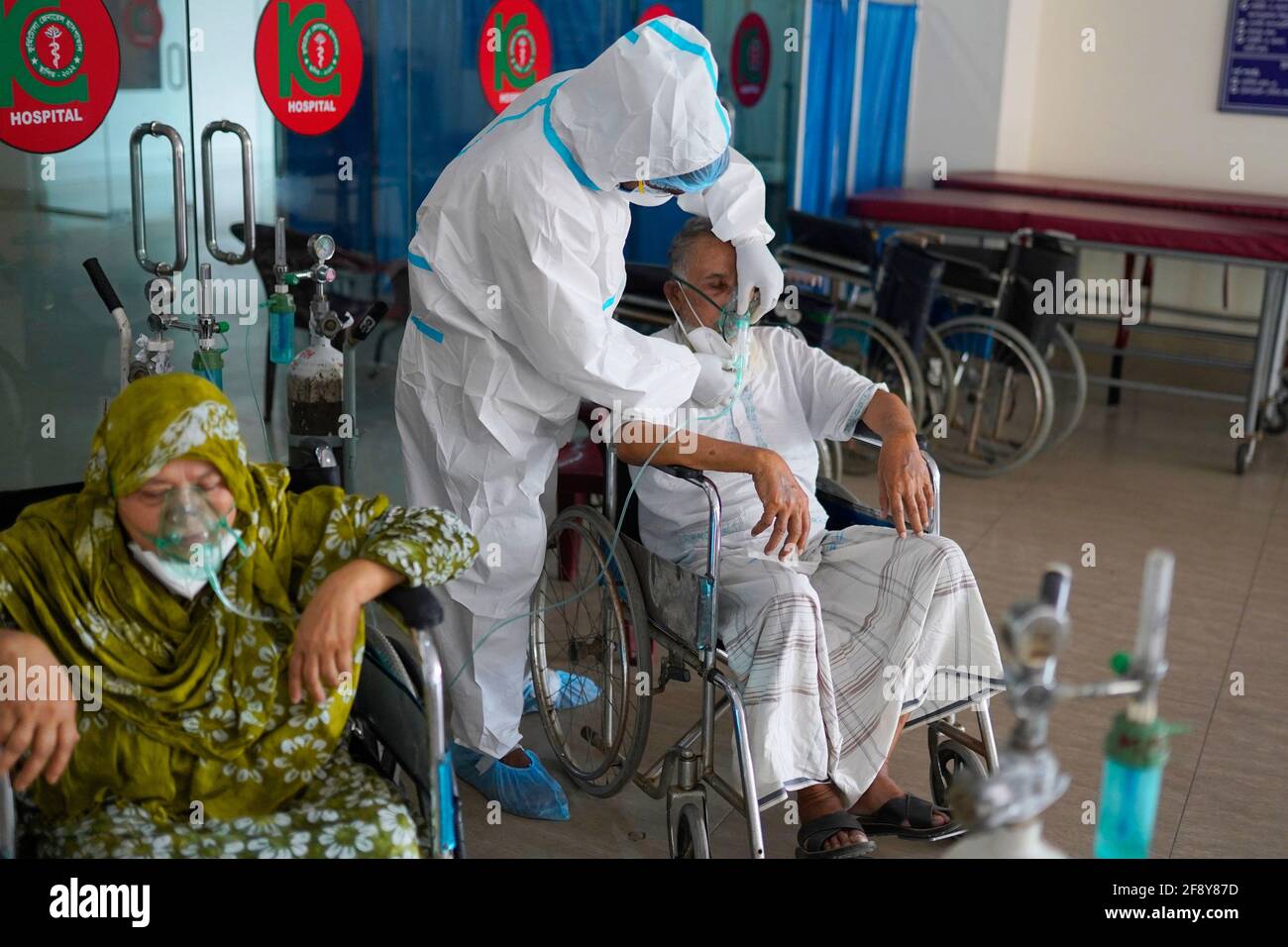 Dhaka, Bangladesh. 15th Apr, 2021. A medical worker wearing a personal protective equipment suite (PPE) adjusts the oxygen mask for an intubated COVID-19 patient at Kurmitola General Hospital in Dhaka.Death toll from the coronavirus infection has surpassed the grim 10,000 mark in Bangladesh as 94 more people have died of the deadly virus in the past 24 hours. (Photo by Sultan Mahmud Mukut/SOPA Images/Sipa USA) Credit: Sipa USA/Alamy Live News Stock Photo