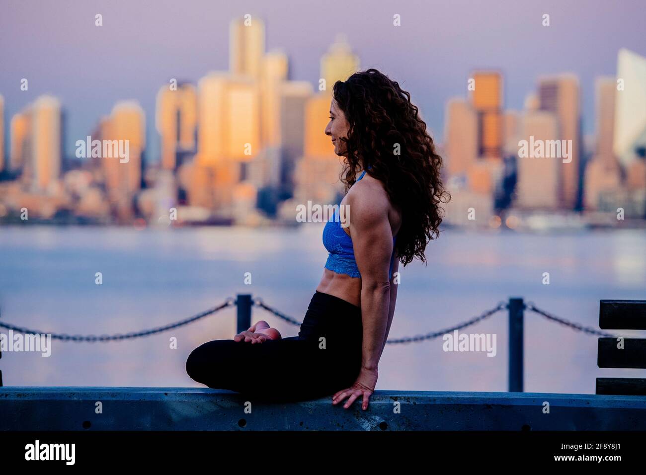 Woman practicing yoga in front of skyline, Seattle, Washington, USA