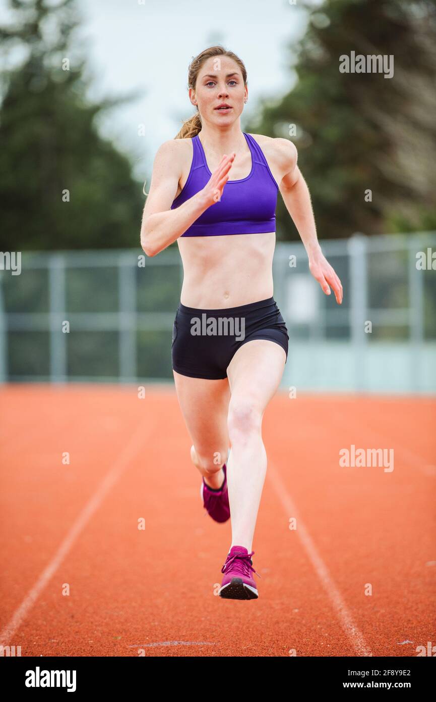 Young woman running on track Stock Photo