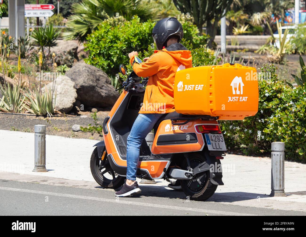 Just Eat courier delivery rider in orange uniform and Just Eat Scooter/motorbike  in Spain Stock Photo - Alamy