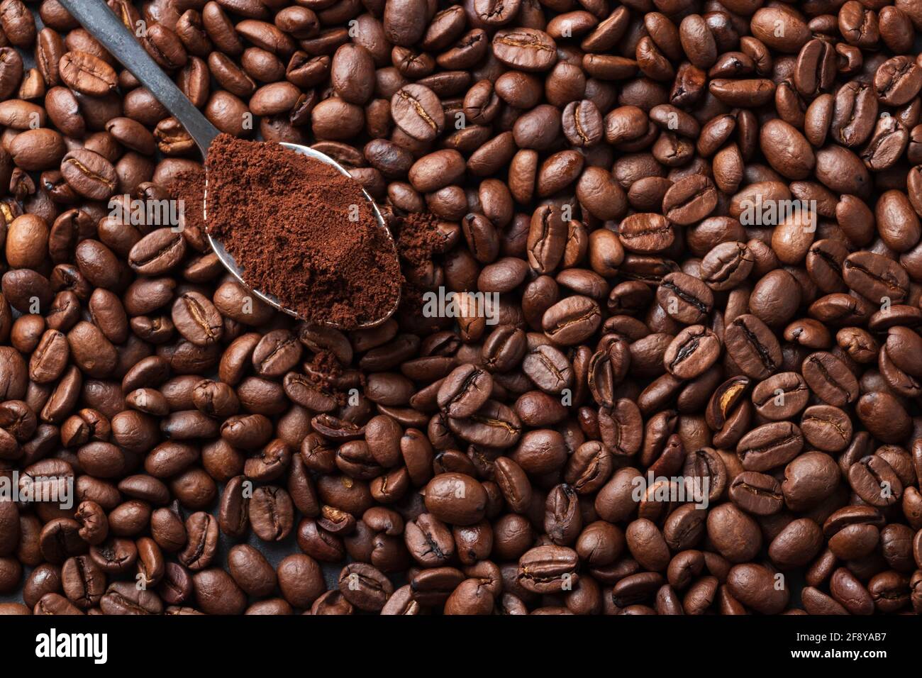 coffee beans background with coffee beans and a teaspoon of ground