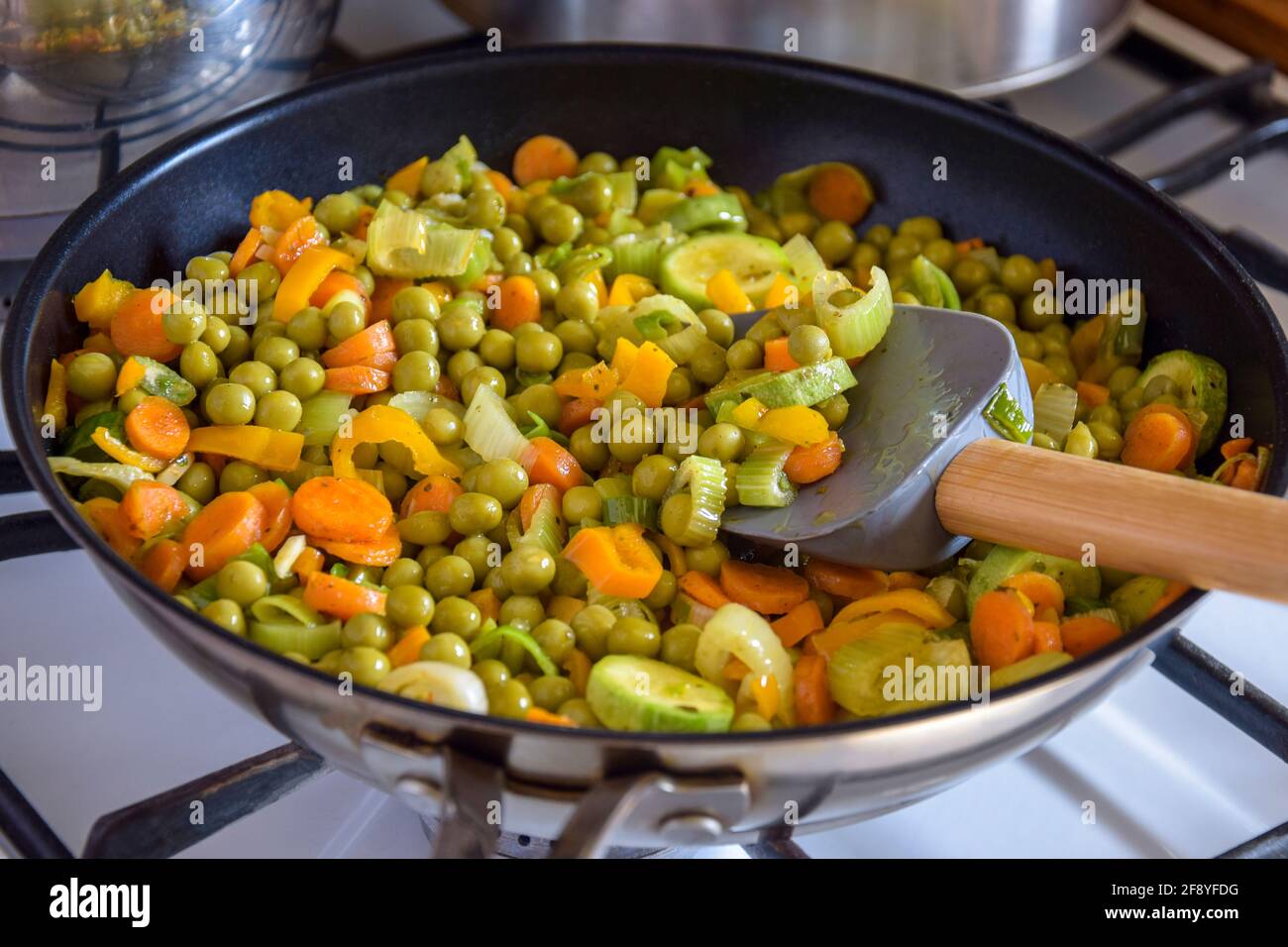 https://c8.alamy.com/comp/2F8YFDG/process-of-cooking-saute-at-home-stewed-vegetables-and-silicone-spatula-with-wooden-handle-in-frying-pan-mixed-ingredients-leek-carrot-zucchini-2F8YFDG.jpg