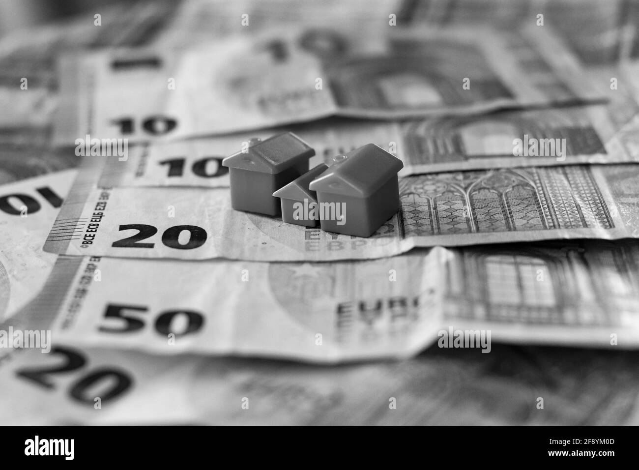 table covered with Euro banknotes with houses on top. Real estate investment concept Stock Photo