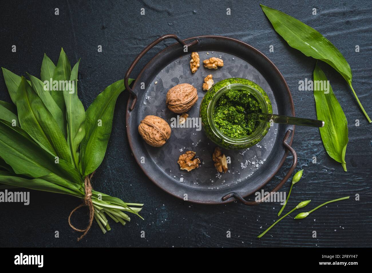 Homemade wild garlic pesto and walnuts on a metal tray, wild garlic