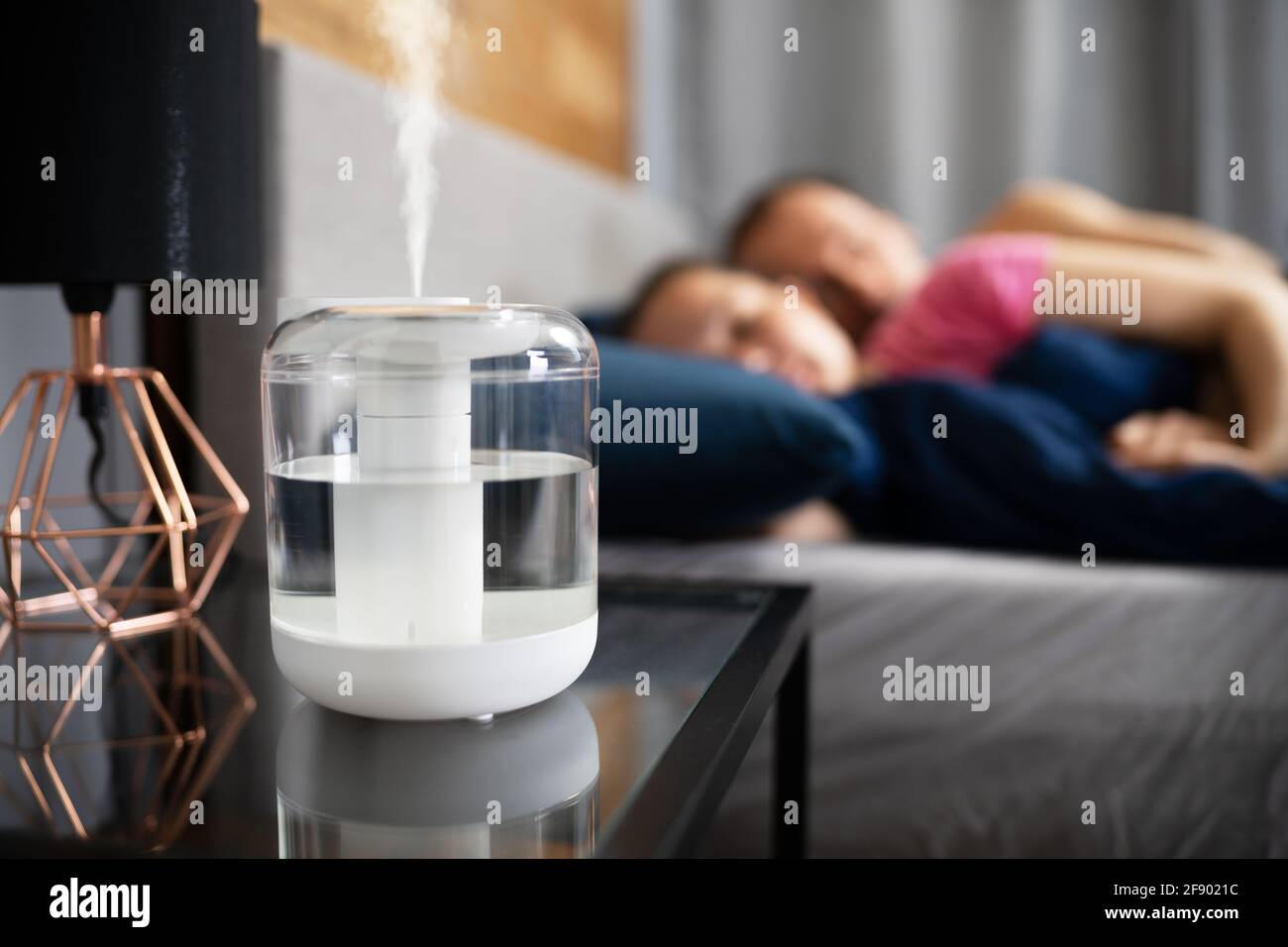 Air Humidifier Steam On Nightstand Near Young Couple Sleeping Stock