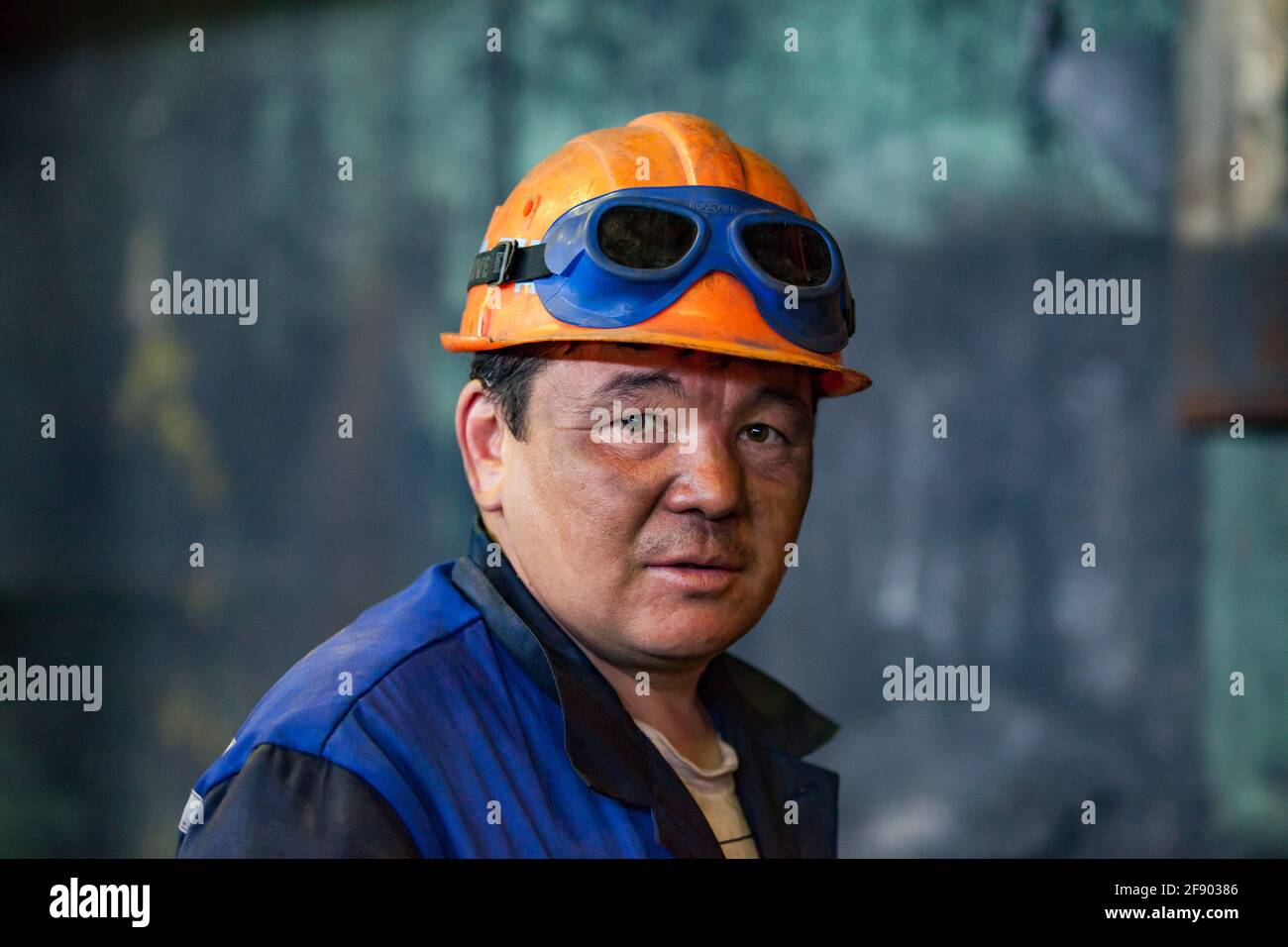 Aksu, Pavlodar region, Kazakhstan. Heat power station. Portrait of adult Asian worker in orange hardhat. With welding protective Stock Photo