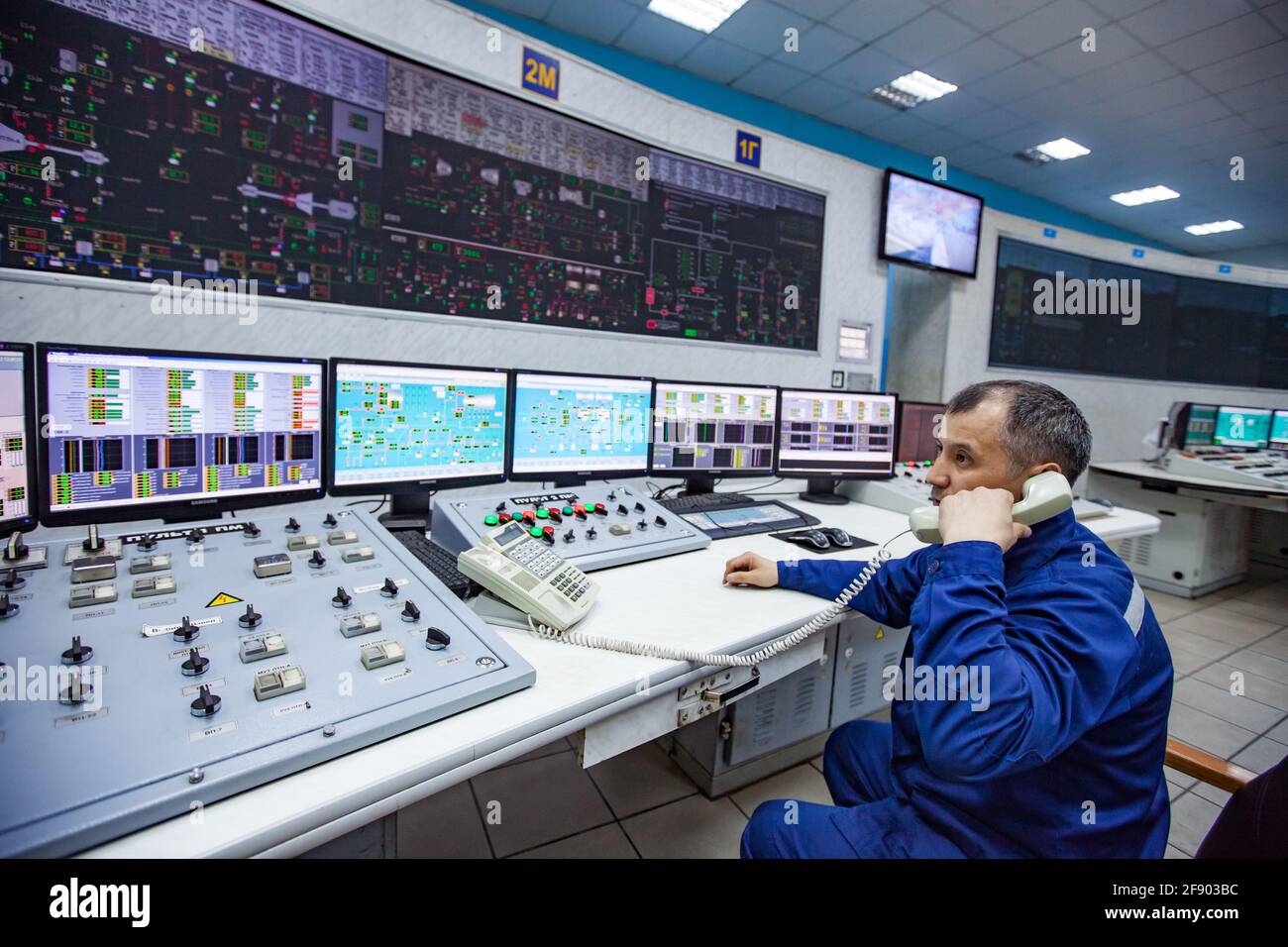 Ekibastuz, Pavlodar region, Kazakhstan: GRES-1 steam power station.  Operator in control room, talking by phone. Control panel on background  Stock Photo - Alamy