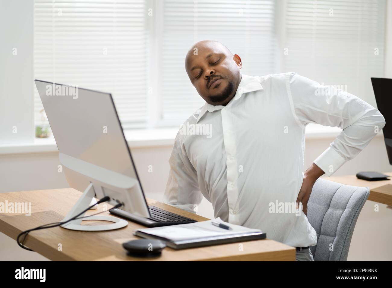 Back Pain Bad Posture At Office Desk Stock Photo