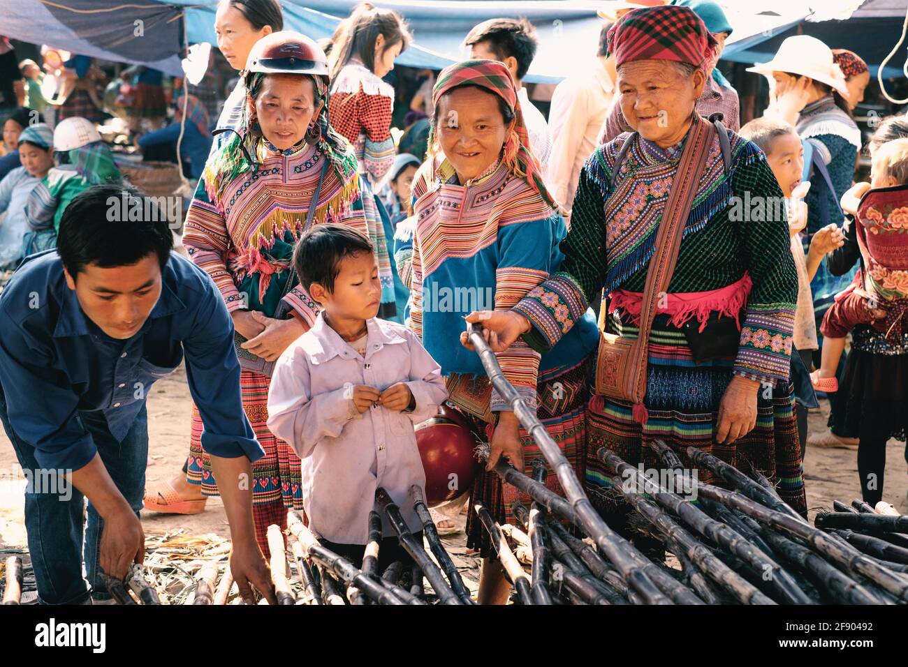 Bac Ha, Vietnam - April 4, 2016: Flower Hmong tribe in colorful traditional clothing with their child at Can Cau Saturday market in Vietnam Stock Photo