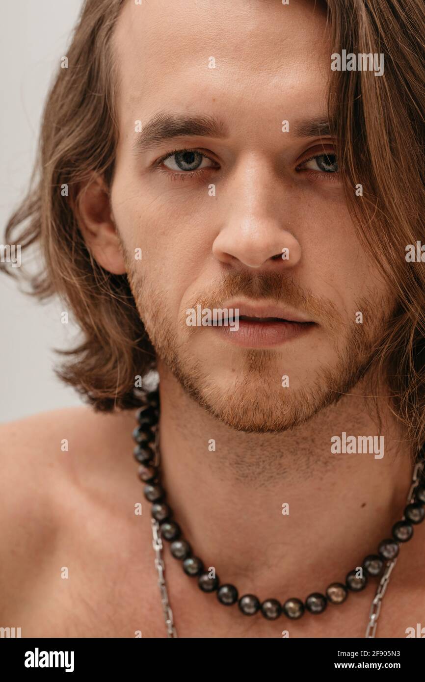 Portrait of a smiling handsome shirtless man wearing necklaces Stock Photo