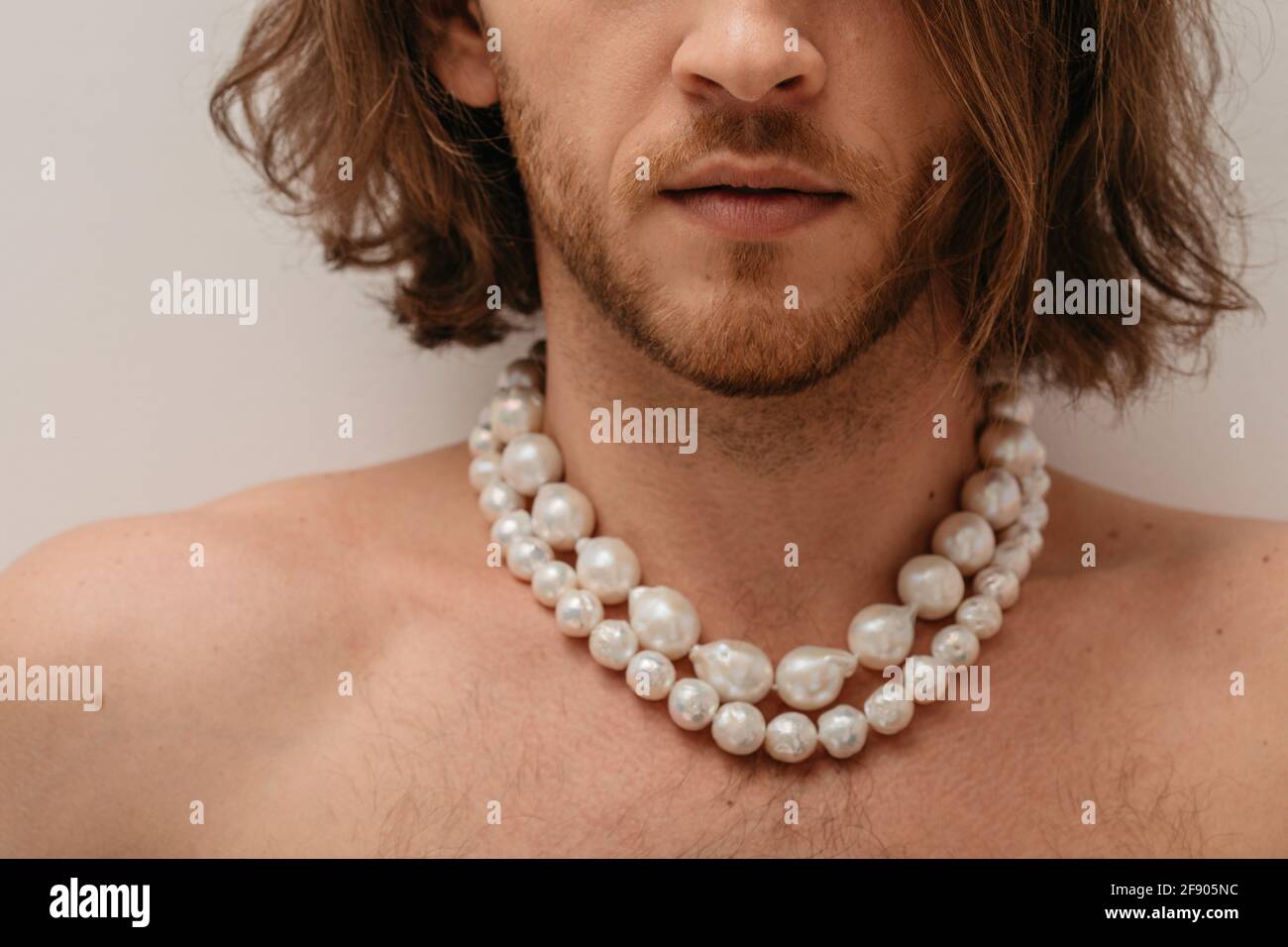 Portrait of a handsome shirtless man wearing pearl necklaces Stock Photo