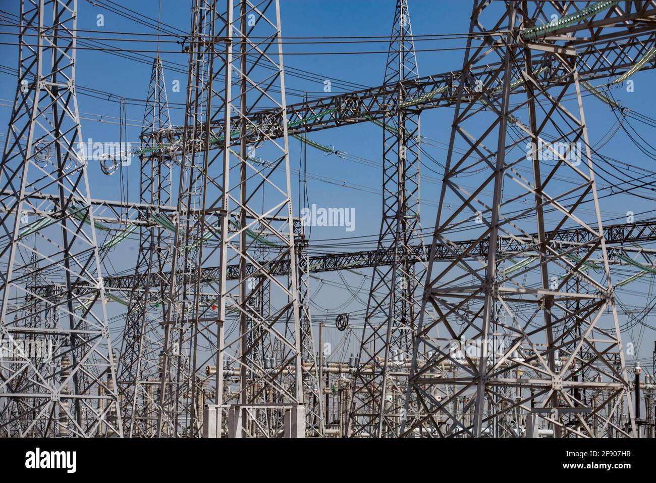 Electricity distribution substation. Pylons and cables. Blue sky background. Stock Photo