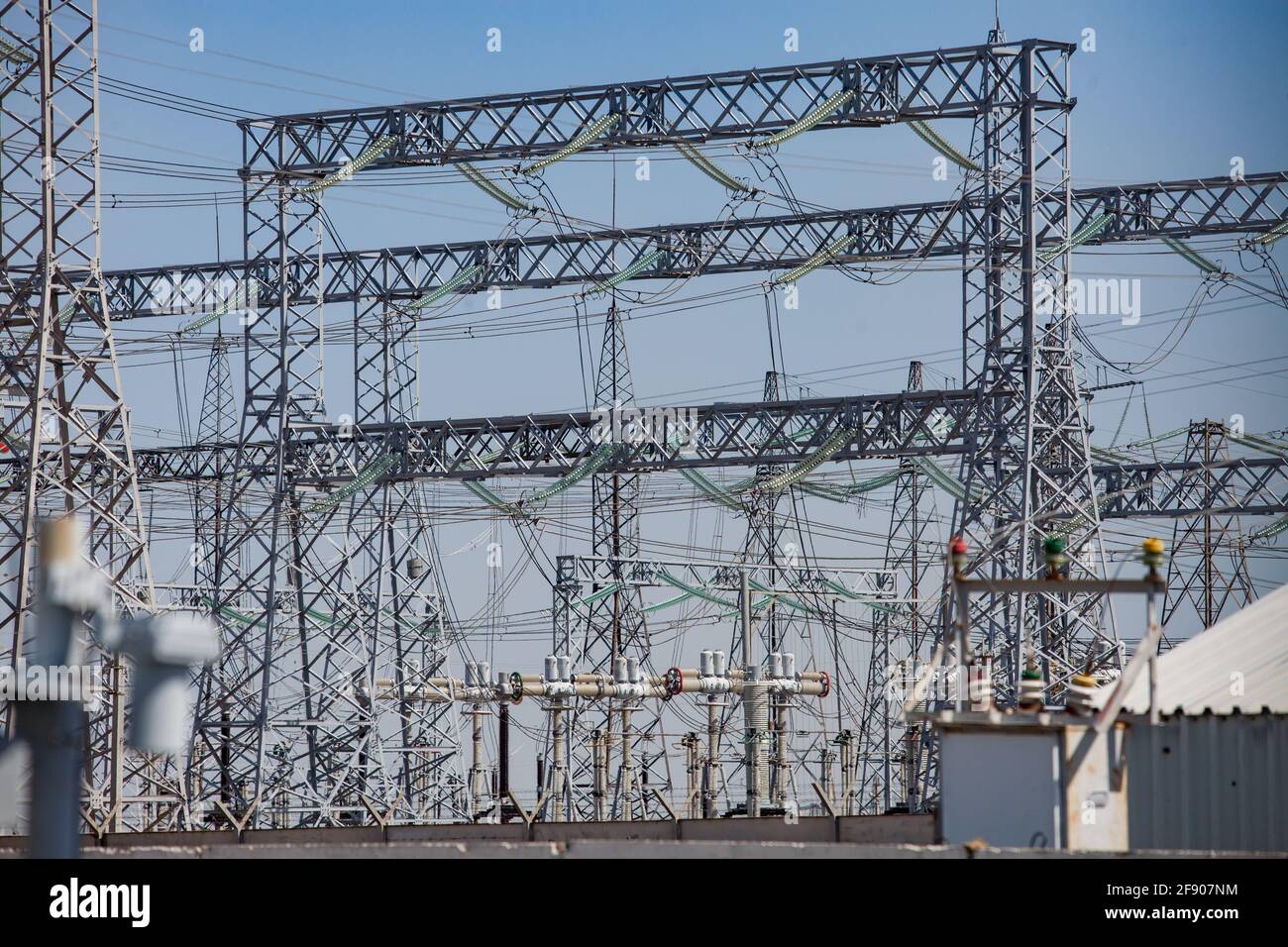 Electric pylons and cables on distribution and transformer substation. Blue sky background. Stock Photo
