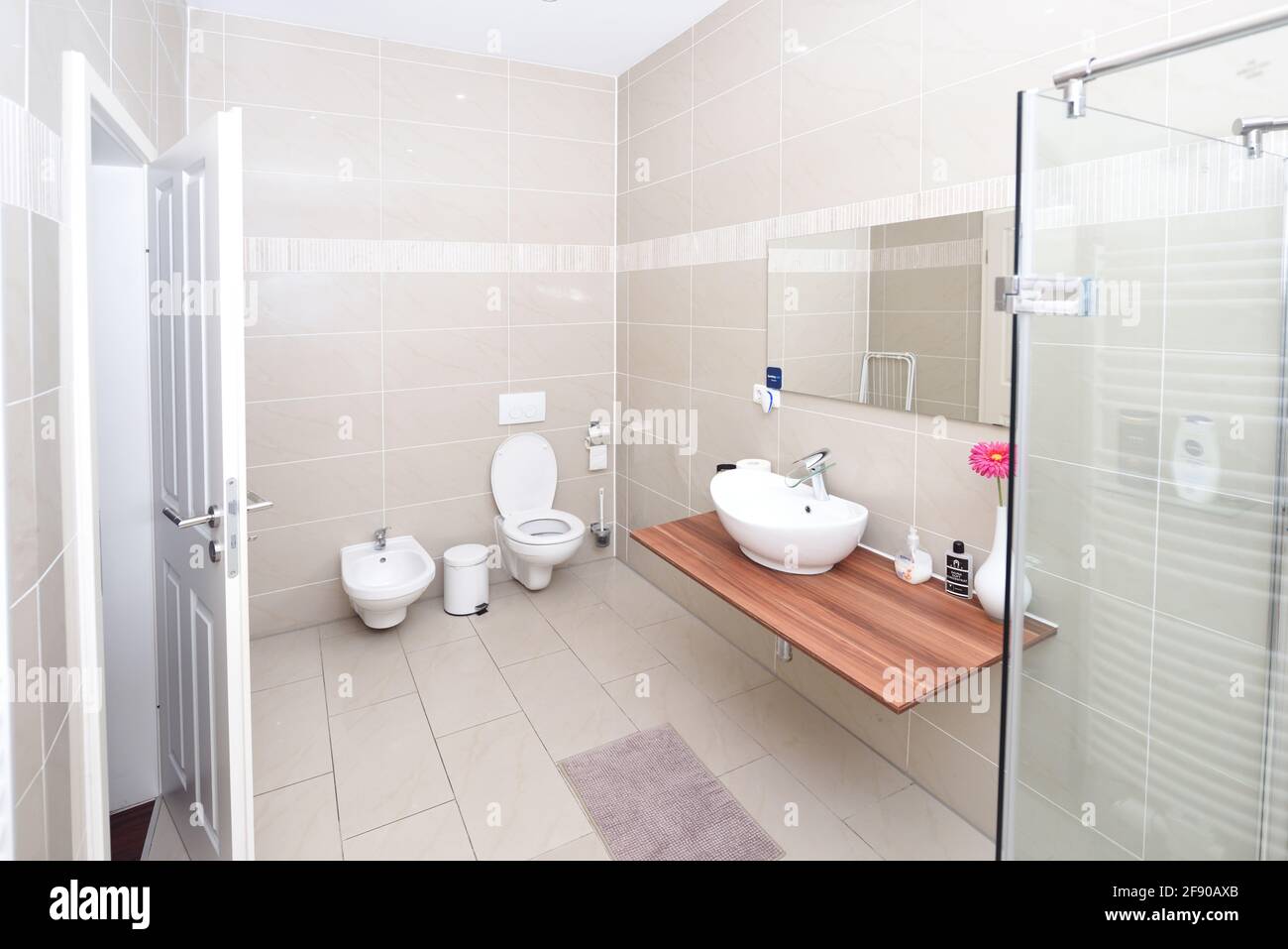 small but luxury bathroom, mirror, white tiles, sink, toilet Stock Photo
