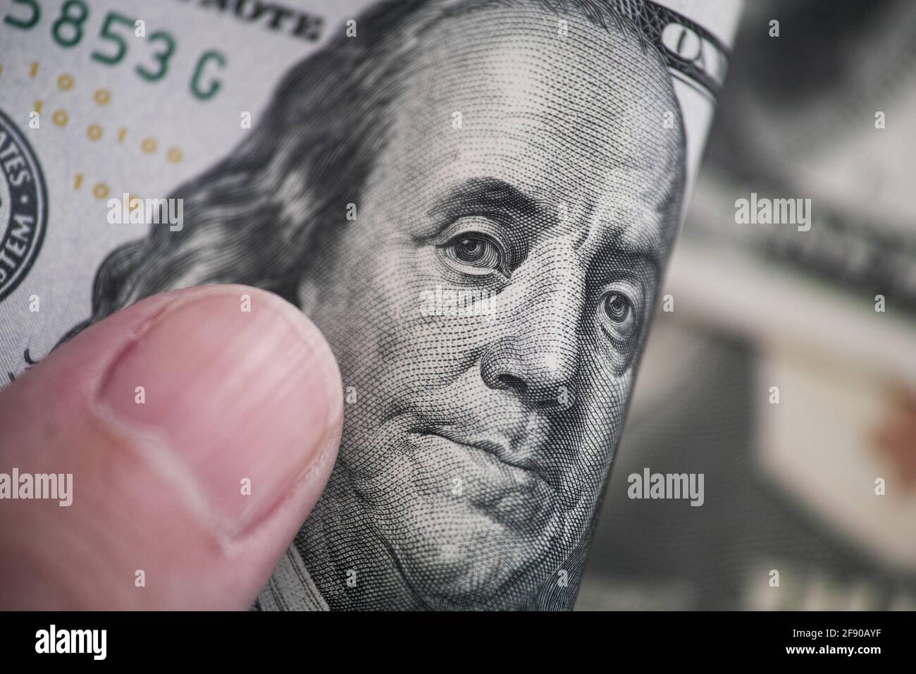 A man holding a one hundred dollar bill in his hand. Close up. Stock Photo