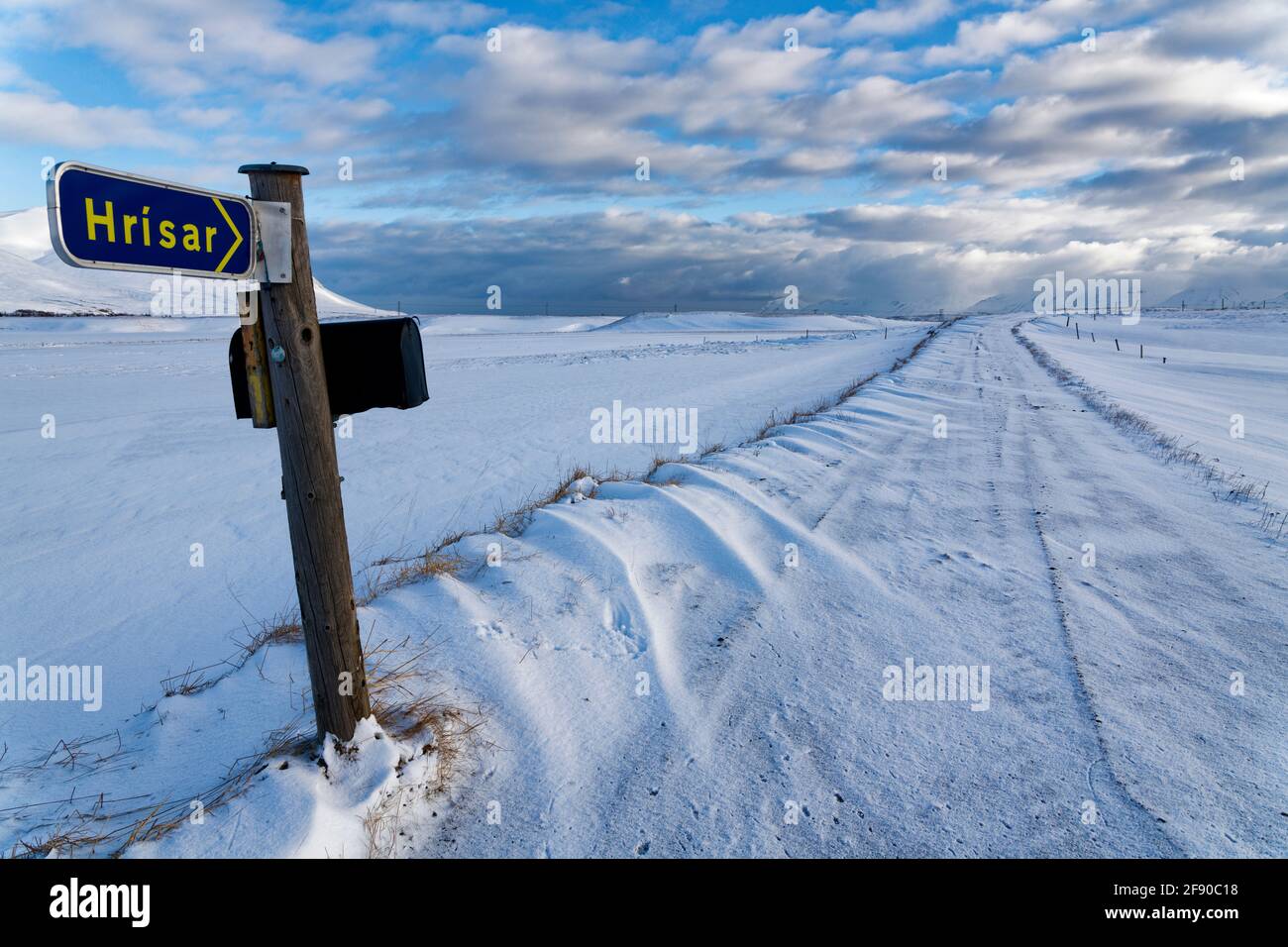 Road sign and road covered in snow in winter, Dalvik, Iceland Stock Photo