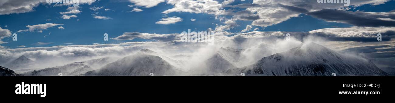 Blue sky and clouds above snow covered mountains, Iceland Stock Photo